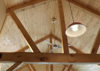 Gambrel barn home interior photo turned towards ceiling showing beams and lighting